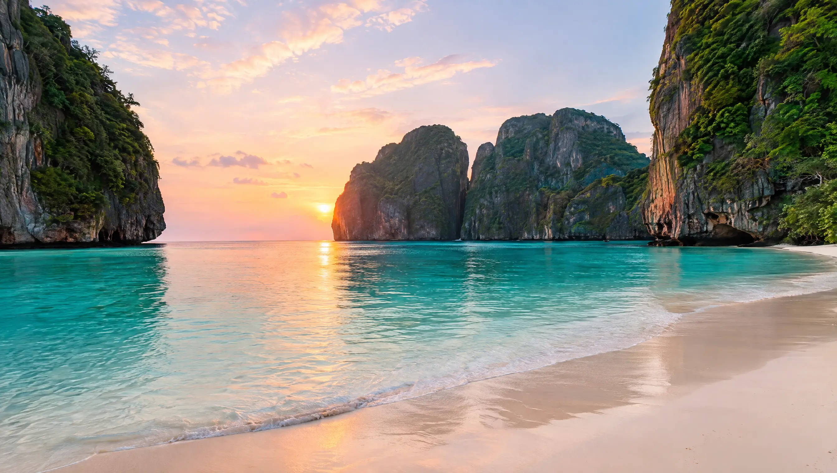 Maya Bay auf Koh Phi Phi Leh bei Sonnenaufgang, menschenleerer Strand zwischen hohen Kalksteinfelsen